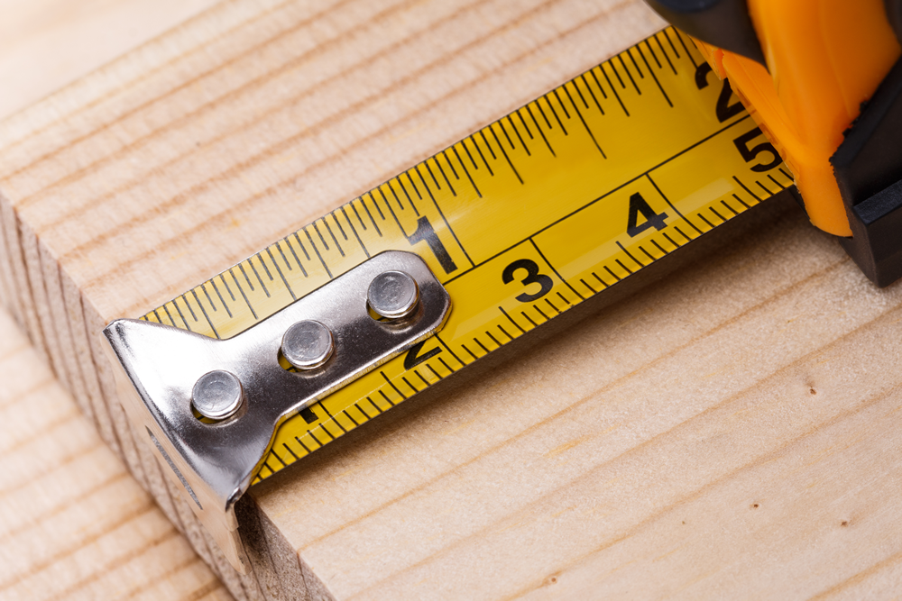 Yellow steel tape measure on wood